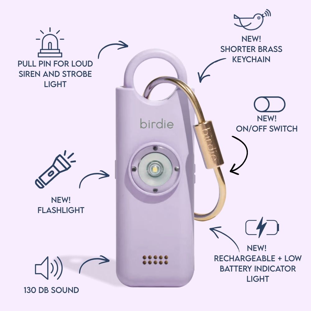 Birdie 3.0 personal safety alarm from She's Birdie, labeled with its features: pull pin for loud siren and strobe light, rechargeable battery, on/off switch, flashlight, and solid brass keychain.
